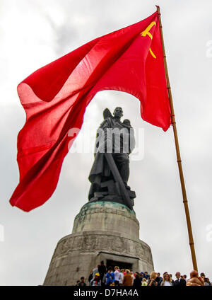 A red Soviet flag waves at the Soviet War Memorial while visitors are lining up to lay flowers and wreaths to commemorate the end of World War II on 08 May 1945, in Berlin, Germany, 08 May 2013. The memorial is dedicated to the fallen World War II soldiers of the Red Army. Photo: HANNIBAL Stock Photo