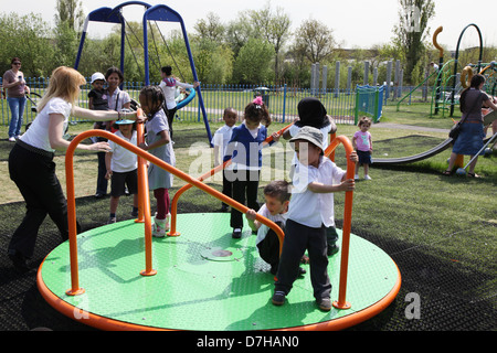 Children playing on a roundabout at Chalkill, Wembley, London Stock Photo