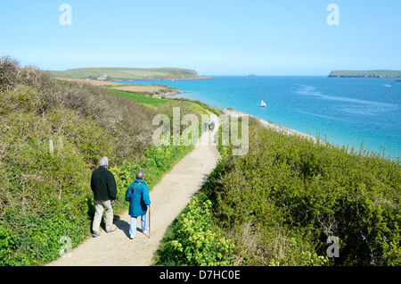 An elderly couple taking a stroll along the south west coast path near Padstow in Cornwall, UK Stock Photo