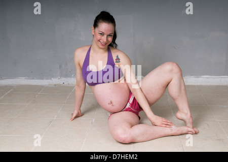 Young flexible Woman in her 20's, nine months pregnant. Model release available Stock Photo