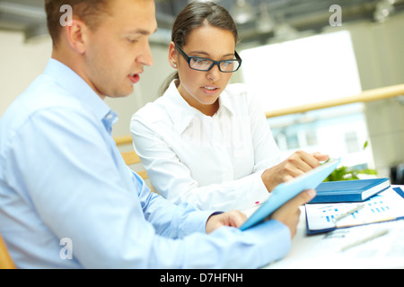 Young business partners discussing document or plan Stock Photo