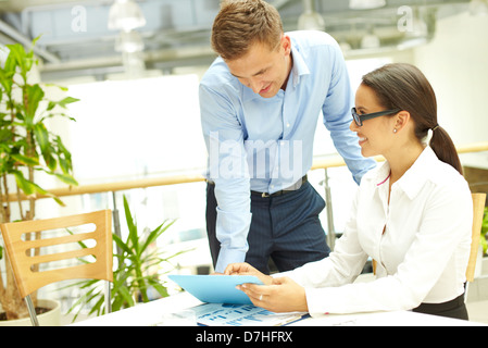 Usual working day at business agency, boss checking the work of his subordinate Stock Photo