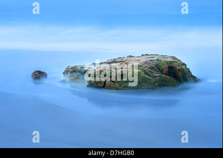 A beautiful slow motion exposure of sea water moving around a small reef in Laguna Beach, California Stock Photo