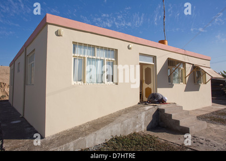 An Afghan man is praying in front of his house Stock Photo