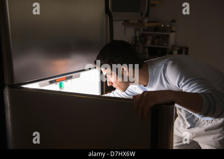 Man opening fridge at night Stock Photo