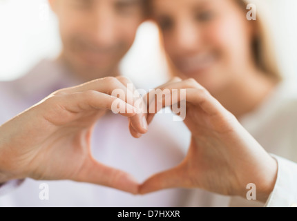 Couple making heart shape with hands Stock Photo