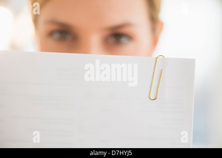 Close-up of young woman reading documents Stock Photo