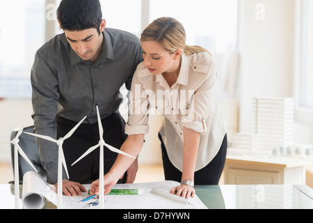 Architects looking at scale models of wind turbines Stock Photo