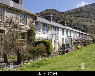 Row of traditional terraced cottages overlooking picturesque Welsh village green in Snowdonia National Park. Beddgelert, Gwynedd, North Wales, UK Stock Photo