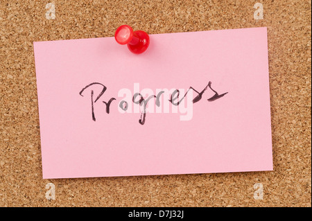Progress word written on paper and pinned on cork board Stock Photo
