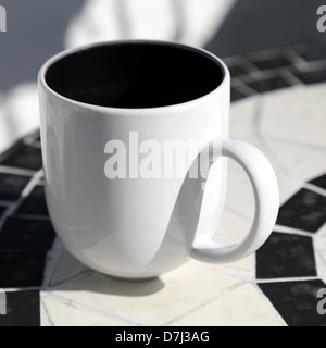 White coffee cup stands on round table Stock Photo