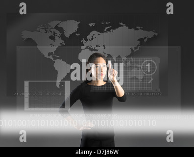 Woman touching high tech screen, studio shot Stock Photo