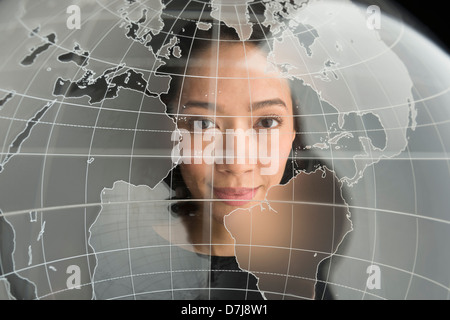Digital portrait of young woman on world map Stock Photo