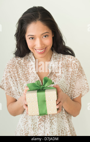 Young woman holding wrapped gift Stock Photo