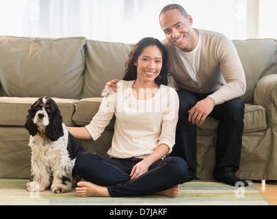 Young couple with dog in living room Stock Photo