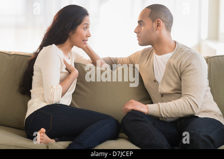 Young couple sitting on couch Stock Photo