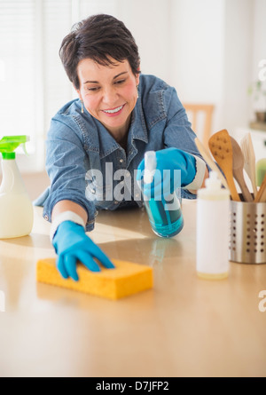 Portrait of mature woman cleaning kitchen Stock Photo