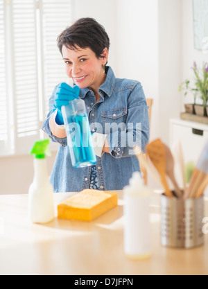 Portrait of mature woman cleaning kitchen Stock Photo