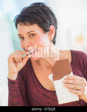 Portrait of mature woman eating chocolate Stock Photo