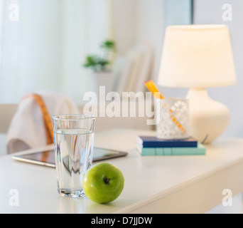 View of glass of water, apple and digital tablet on table Stock Photo