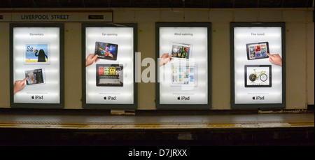 Ipad backlit advertising panels on underground train station platform Liverpool Street station London England UK Stock Photo