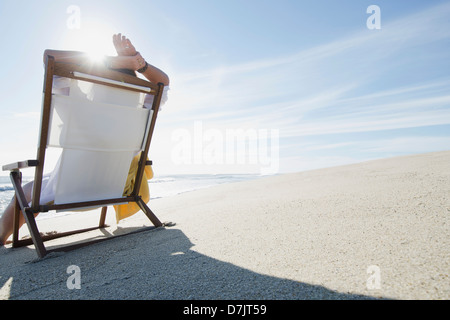 USA, Massachusetts, Nantucket Island, Rear view of woman relaxing on chair at beach Stock Photo