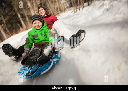 USA, Utah, Highland, Young woman sledding with boy (4-5) Stock Photo
