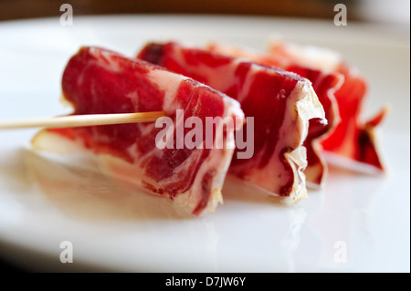A slices of jamon, strung on a wooden skewer Stock Photo