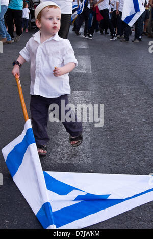 Jerusalem, Israel. 8th May 2013. A young boy holds an Israeli flag joining the annual Dance of Flags and Jerusalem Day celebrations. Jerusalem, Israel. 8-May-2013.  More than fifty thousand youths belonging to the religious Zionist streams celebrate in the annual Dance of Flags rejoicing the anniversary of the reunification of Jerusalem in the 1967 Six-Day-War in a demonstration of Jewish pride. Credit:  Nir Alon / Alamy Live News Stock Photo