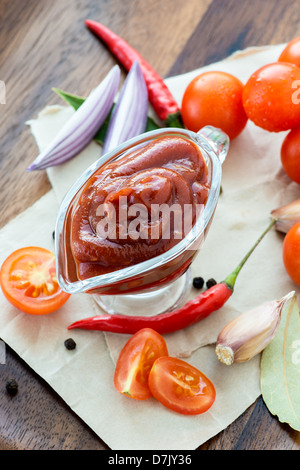 Traditional homemade tomato sauce with ingredients on wooden background, selective focus Stock Photo