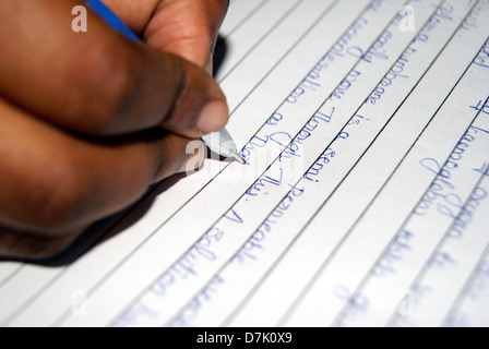 Student writing in Project Note Book With Blue Pen for exam , College Girl Hand Writing and Pen point focus view Stock Photo