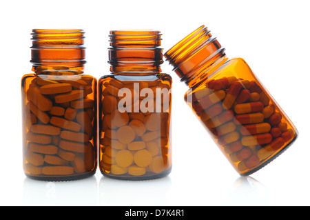Three brown prescription medicine bottles on a white surface with reflection. Stock Photo