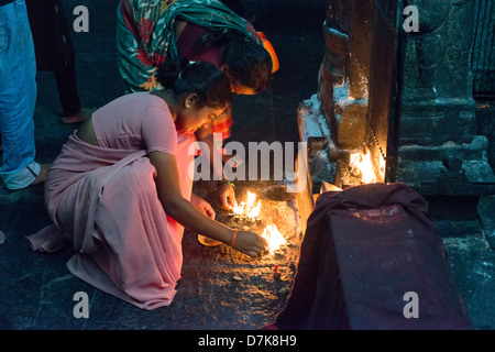 Hindu devotees light ghee lamps at a shrine in the Arunachaleswara Temple in Tiruvannamalai, Tamil Nadu, India Stock Photo