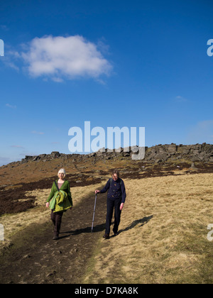 Couple of  walkers on Stanage Edge in the Peak District National Park Derbyshire England Stock Photo