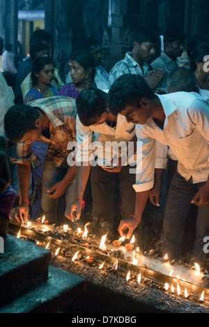 Hindu devotees light ghee lamps at a shrine in the Arunachaleswara Temple in Tiruvannamalai, Tamil Nadu, India Stock Photo