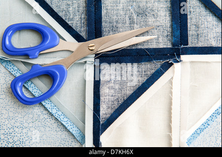 Quilting or patchwork materials and tools with scissors showing blue and white patterned fat quarters Stock Photo