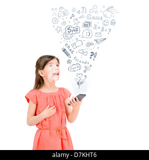 Happy cute little girl in red dress holding a smartphone in hand and fascinated looking up at the icons of different apps Stock Photo