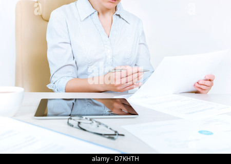 Busy businesswoman wearing in casual shirt sitting at desk and check documents in the office Stock Photo