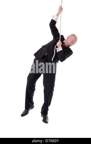 Businessman hanging onto a rope fearing from below isolated on white Stock Photo