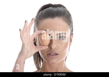 Model Released. Young Woman Holding a Brown Egg Stock Photo