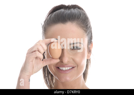 Model Released. Young Woman Holding a Brown Egg Stock Photo