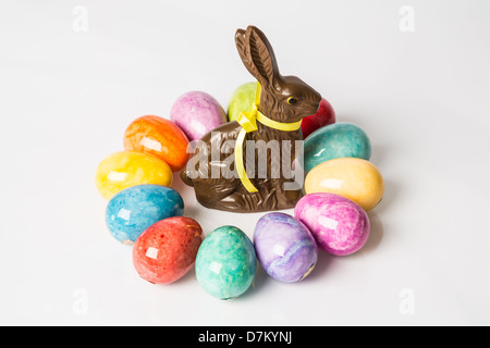 Easter Eggs in a circle around a Chocolate Easter bunny. Studio isolated. Stock Photo