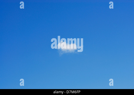 Small white fluffy cloud against a deep blue sky Stock Photo