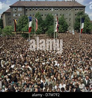 Cheering crowd in front of the town hall Schoeneberg in Berlin during the visit of US president John F. Kennedy on 26 June 1963. Sign in the back says ' when will the wall be falling ? ' Stock Photo