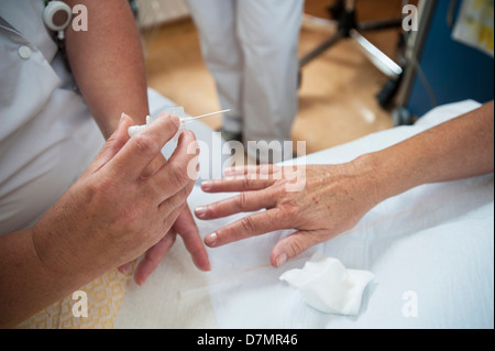 Nurse preparing a patient for an IV line Stock Photo