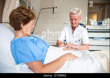 Nurse preparing a patient for an IV line Stock Photo