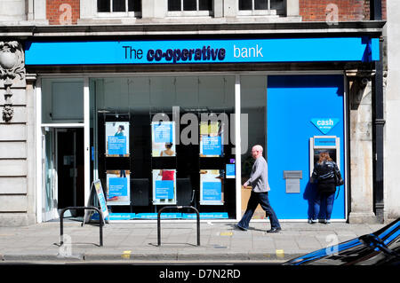 People walk past a  Co-operative bank branch in central London, UK Stock Photo