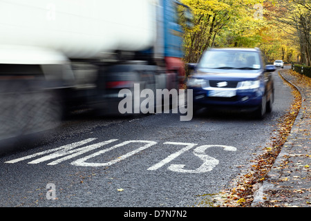 Motion blurred traffic travelling on a local country road in Autumn, Scotland, UK Stock Photo