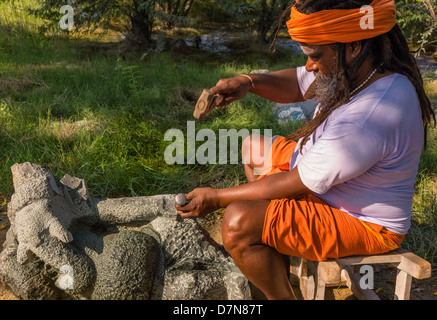 Hindu priest works stone to create a sculpture of Lord Ganesh, Hindu God, in Mamallapuram, Tamil Nadu, India. Stock Photo