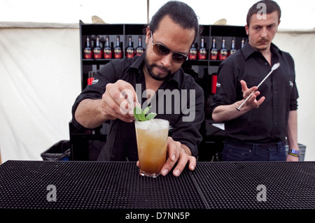 BARMAN/ BARTENDER PREPARES AND MAKES FINISHING TOUCH TO A COCKTAIL AT BAR BACKSTAGE AT LOVEBOX FESTIVAL, 2012 Stock Photo